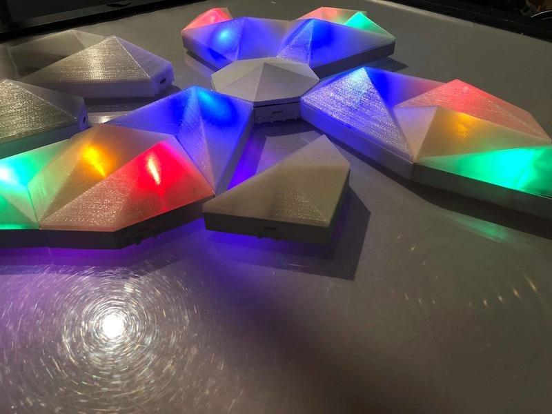 Plastic geometric pieces on a table, some lit up.